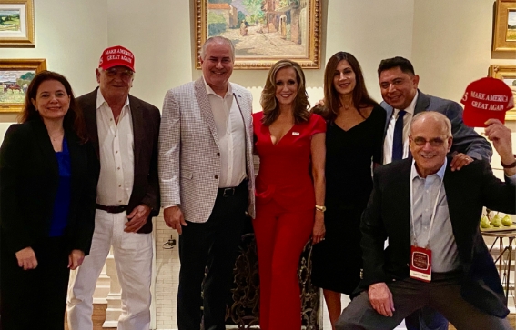 Al Santos junto a un grupo de personas con sombreros de Make America Great Again