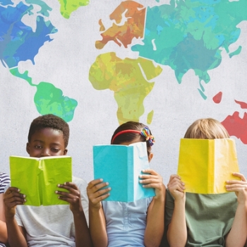 Children reading books in front of a map of the world